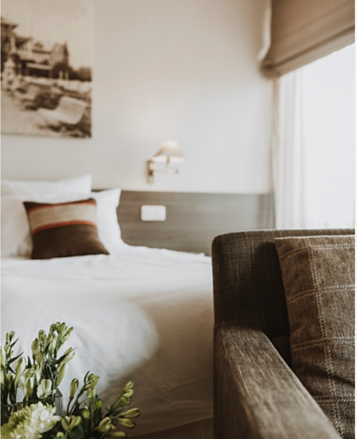 Hotelkamer met zetel en bloemen